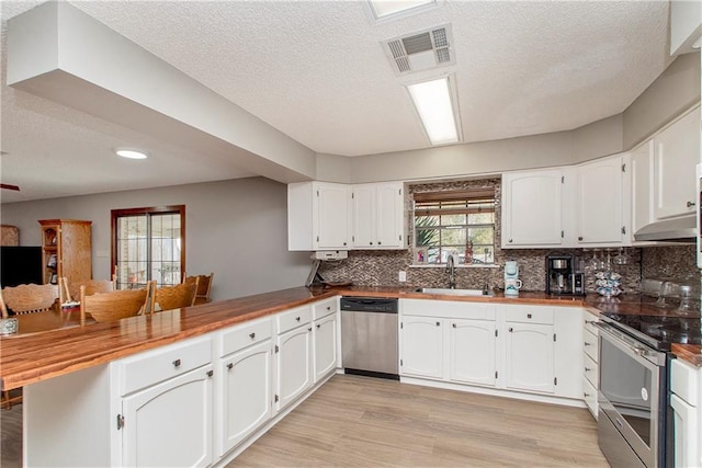 kitchen featuring kitchen peninsula, sink, white cabinets, and appliances with stainless steel finishes