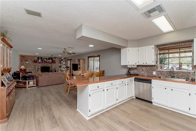 kitchen with dishwasher, white cabinets, sink, ceiling fan, and kitchen peninsula