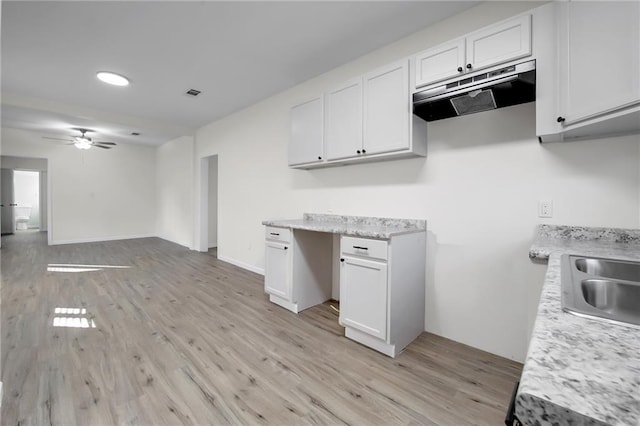 kitchen featuring ceiling fan, light wood-type flooring, white cabinetry, and sink