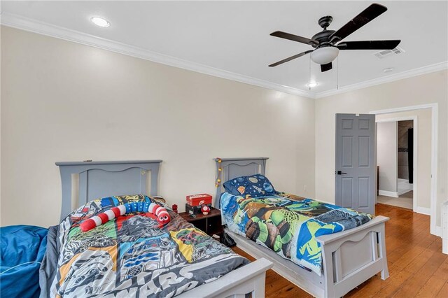 bedroom featuring ceiling fan, ornamental molding, and hardwood / wood-style flooring