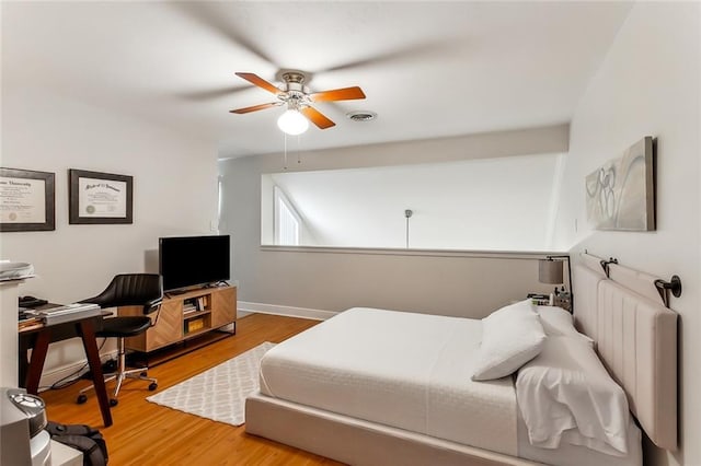 bedroom with hardwood / wood-style flooring, ceiling fan, and radiator heating unit