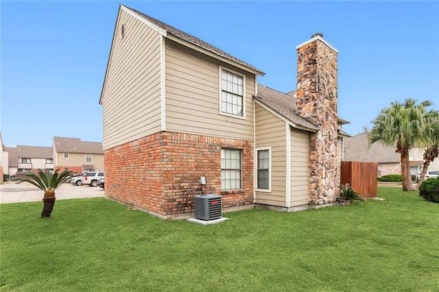 back of house featuring a lawn and cooling unit