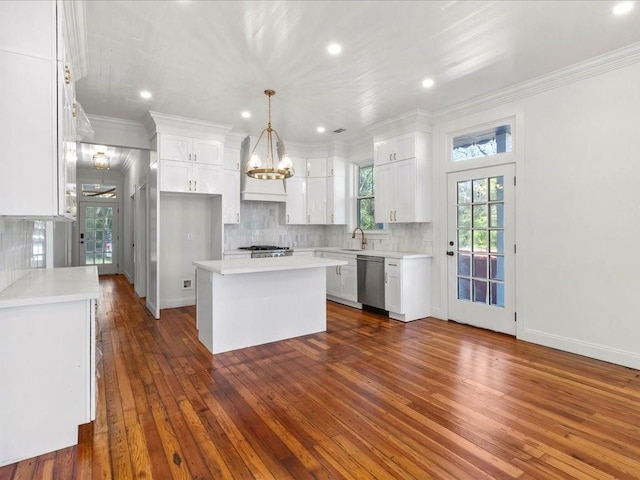 kitchen featuring hanging light fixtures, white cabinetry, a center island, and stainless steel dishwasher