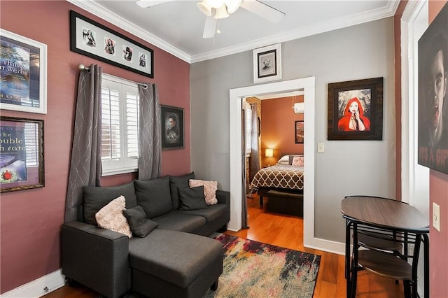 living area featuring ceiling fan, wood-type flooring, and crown molding