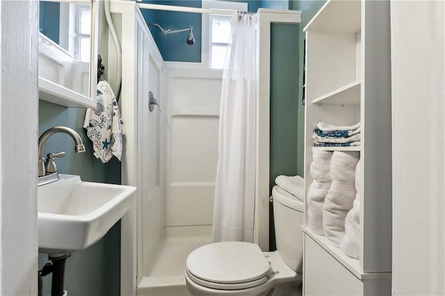 bathroom featuring a shower with curtain, toilet, and sink