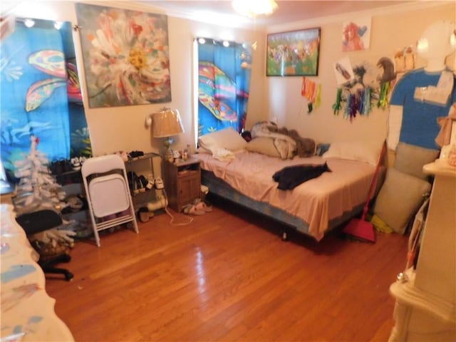 bedroom with hardwood / wood-style flooring and crown molding