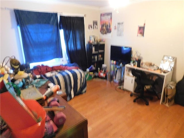 bedroom featuring wood-type flooring and ornamental molding