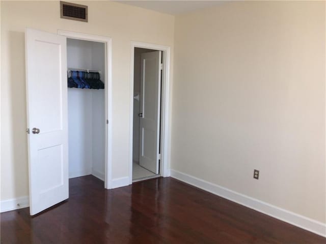 1205 St Charles Ave Unit 916, New Orleans, LA 70130 - unfurnished bedroom with dark wood-type flooring and a closet
