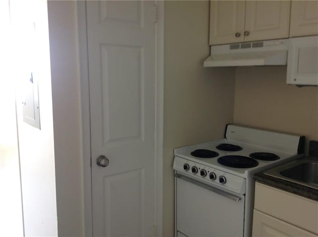 1205 St Charles Ave Unit 916, New Orleans, LA 70130 - kitchen with electric stove, under cabinet range hood, white cabinets, and dark countertops