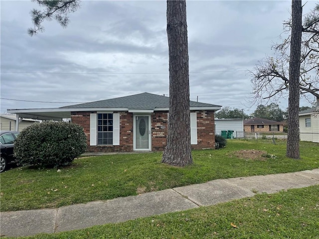 view of front of property with a front lawn and a carport