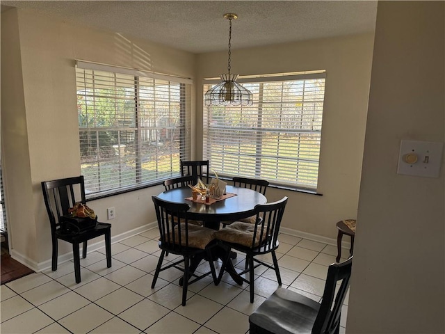 tiled dining room featuring a textured ceiling