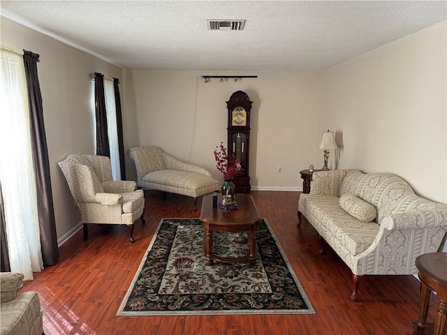 living room featuring a textured ceiling and dark wood-type flooring