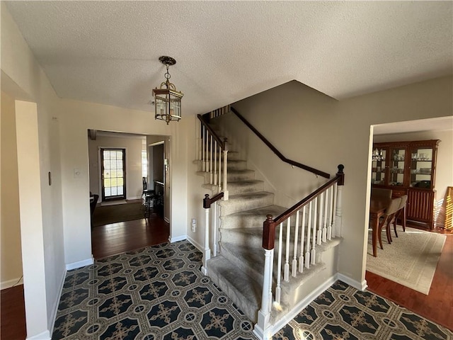 10923 Chaucer St, New Orleans, LA 70127 - entryway featuring a chandelier, stairway, a textured ceiling, and wood finished floors