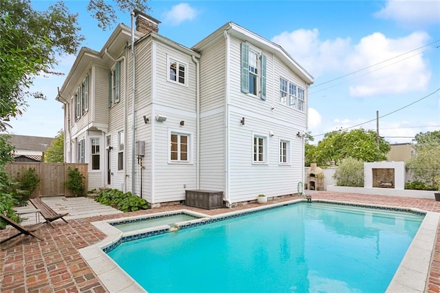 back of house with a pool with hot tub and a patio area