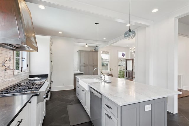 kitchen with sink, light stone counters, island range hood, an island with sink, and stainless steel appliances