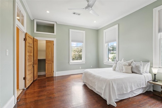 bedroom with crown molding, dark hardwood / wood-style floors, and ceiling fan