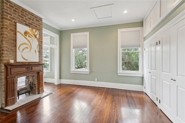 unfurnished living room featuring hardwood / wood-style flooring, a fireplace, and crown molding