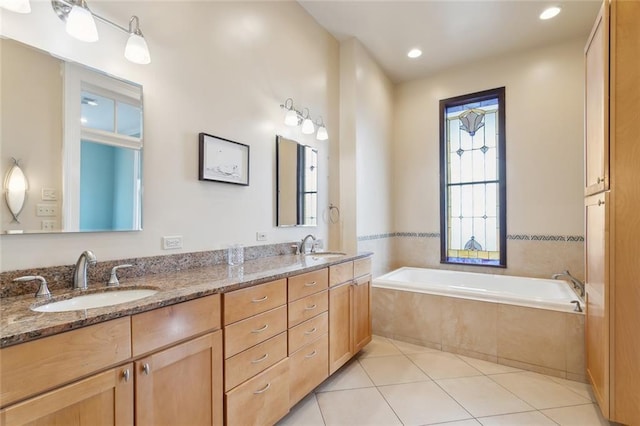 bathroom featuring vanity, tiled tub, and tile patterned floors