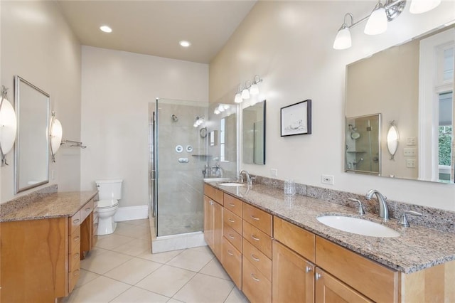 bathroom featuring tile patterned flooring, toilet, vanity, and a shower with shower door