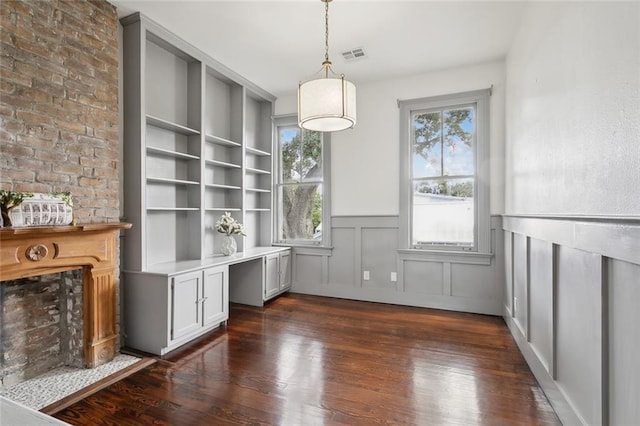 unfurnished dining area with dark wood-type flooring