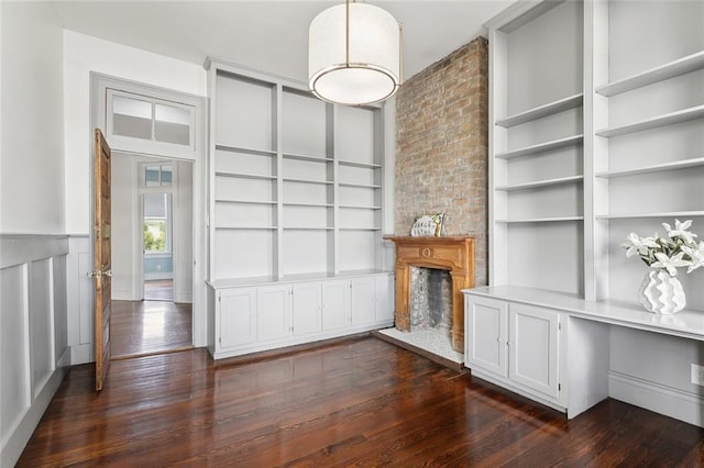 unfurnished living room featuring dark hardwood / wood-style floors and built in features