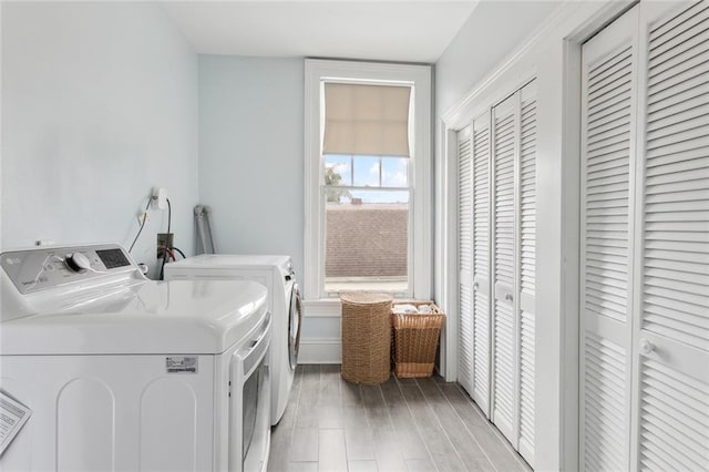 clothes washing area featuring light wood-type flooring and independent washer and dryer