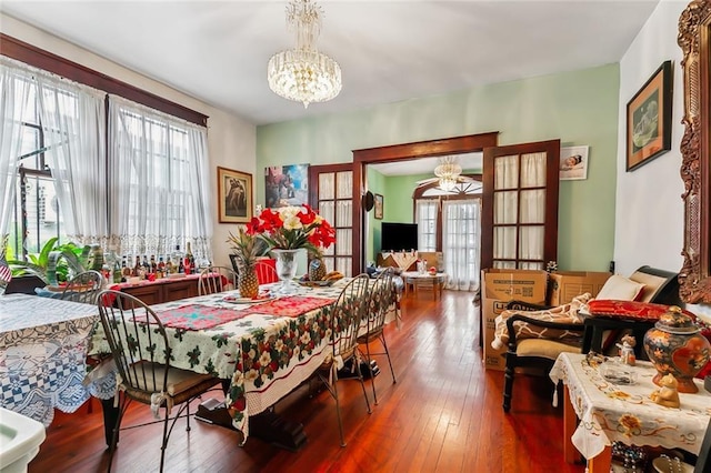 dining space featuring a wealth of natural light, french doors, hardwood / wood-style floors, and an inviting chandelier