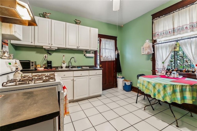 kitchen featuring ventilation hood, white cabinetry, sink, and gas range gas stove