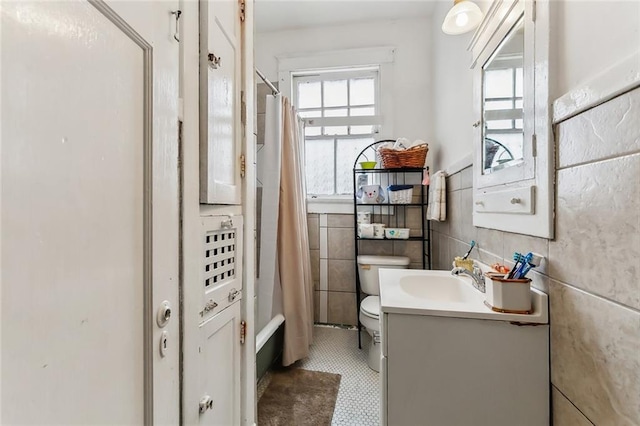 full bathroom with vanity, shower / bath combination with curtain, tile walls, and toilet