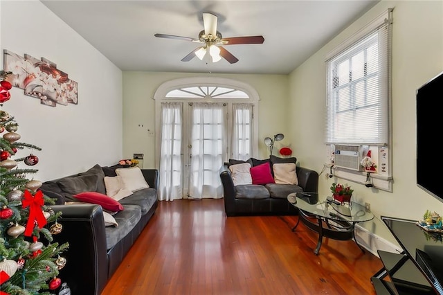 living room featuring cooling unit, ceiling fan, and dark wood-type flooring