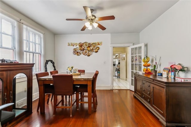 dining space featuring ceiling fan and dark wood-type flooring