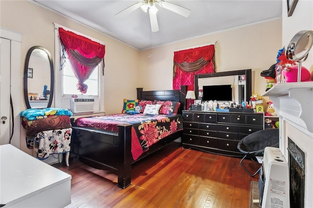 bedroom featuring ceiling fan, cooling unit, and dark wood-type flooring