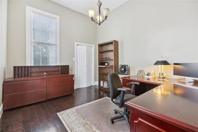 office featuring dark hardwood / wood-style floors and an inviting chandelier