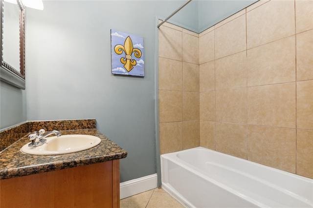 bathroom featuring tile patterned flooring, vanity, and tiled shower / bath combo