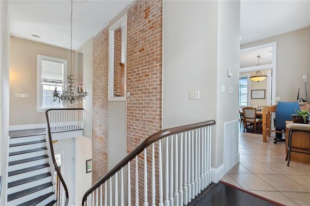 1027 Ninth St, New Orleans, LA 70115 - hallway featuring an upstairs landing, a chandelier, and tile patterned floors
