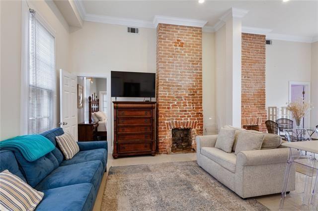 1027 Ninth St, New Orleans, LA 70115 - living room featuring ornamental molding and a brick fireplace