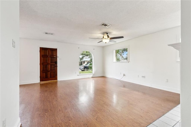 spare room with a textured ceiling, ceiling fan, and hardwood / wood-style flooring