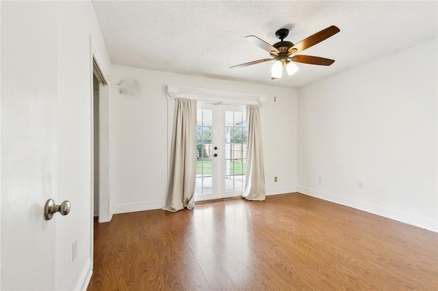 spare room with a textured ceiling, ceiling fan, hardwood / wood-style floors, and french doors