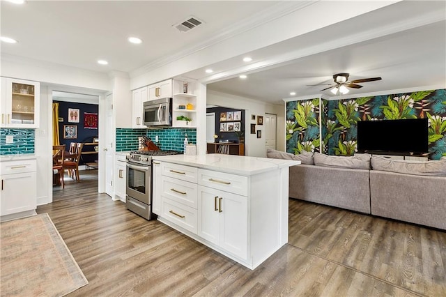 kitchen with decorative backsplash, white cabinetry, and appliances with stainless steel finishes