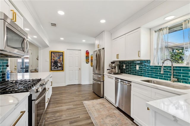 kitchen with light stone counters, sink, white cabinetry, and stainless steel appliances