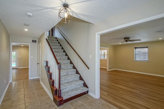 stairway with tile patterned flooring and ceiling fan