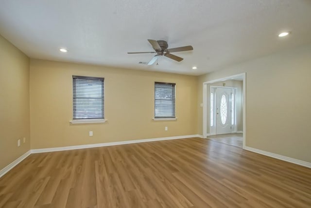 spare room with ceiling fan, a healthy amount of sunlight, and light wood-type flooring