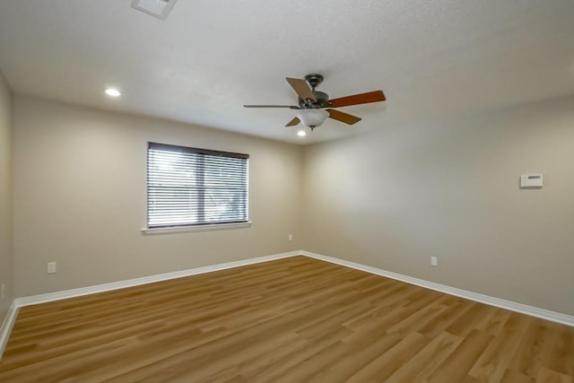 empty room with ceiling fan and light hardwood / wood-style flooring