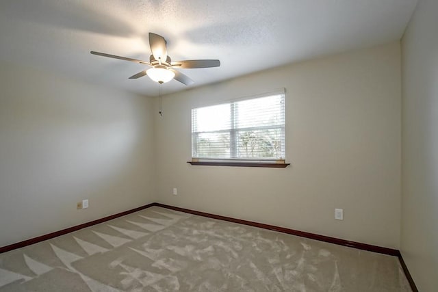 empty room featuring carpet flooring and ceiling fan