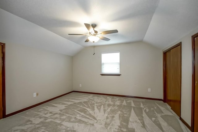 additional living space with ceiling fan, light colored carpet, and lofted ceiling