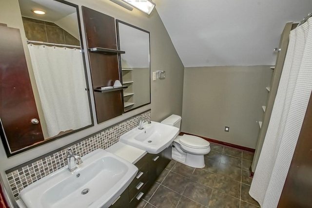 bathroom with tasteful backsplash, sink, vaulted ceiling, and toilet