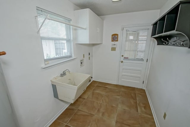 interior space with tile patterned floors, hookup for a washing machine, cabinets, and sink