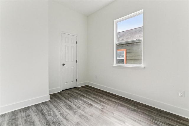 unfurnished room with plenty of natural light and dark wood-type flooring