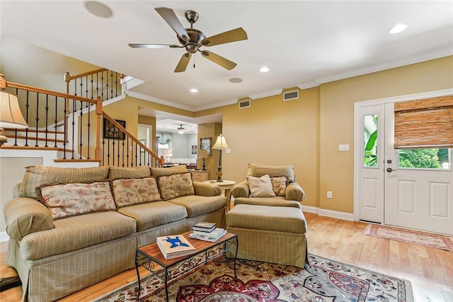 living area with visible vents, light wood-style flooring, ornamental molding, stairs, and recessed lighting