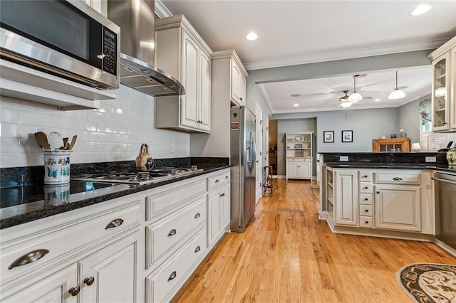 kitchen with stainless steel appliances, backsplash, light wood-style floors, ornamental molding, and exhaust hood